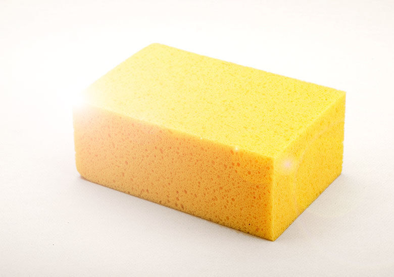 Yellow rectangular block of open cell foam sponge.